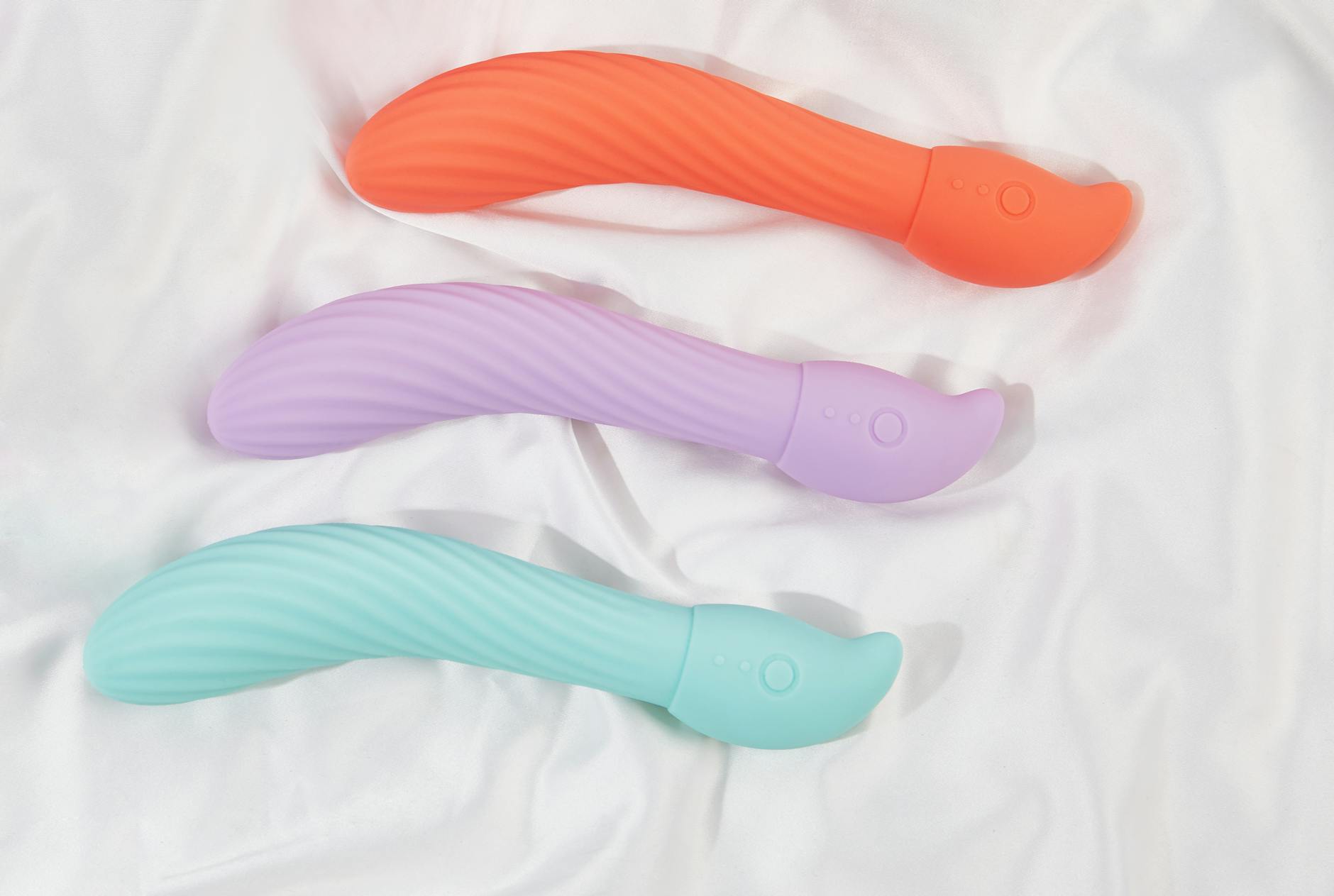Pink vibrator on a purple background with heart confetti and candles for a romantic vibe.