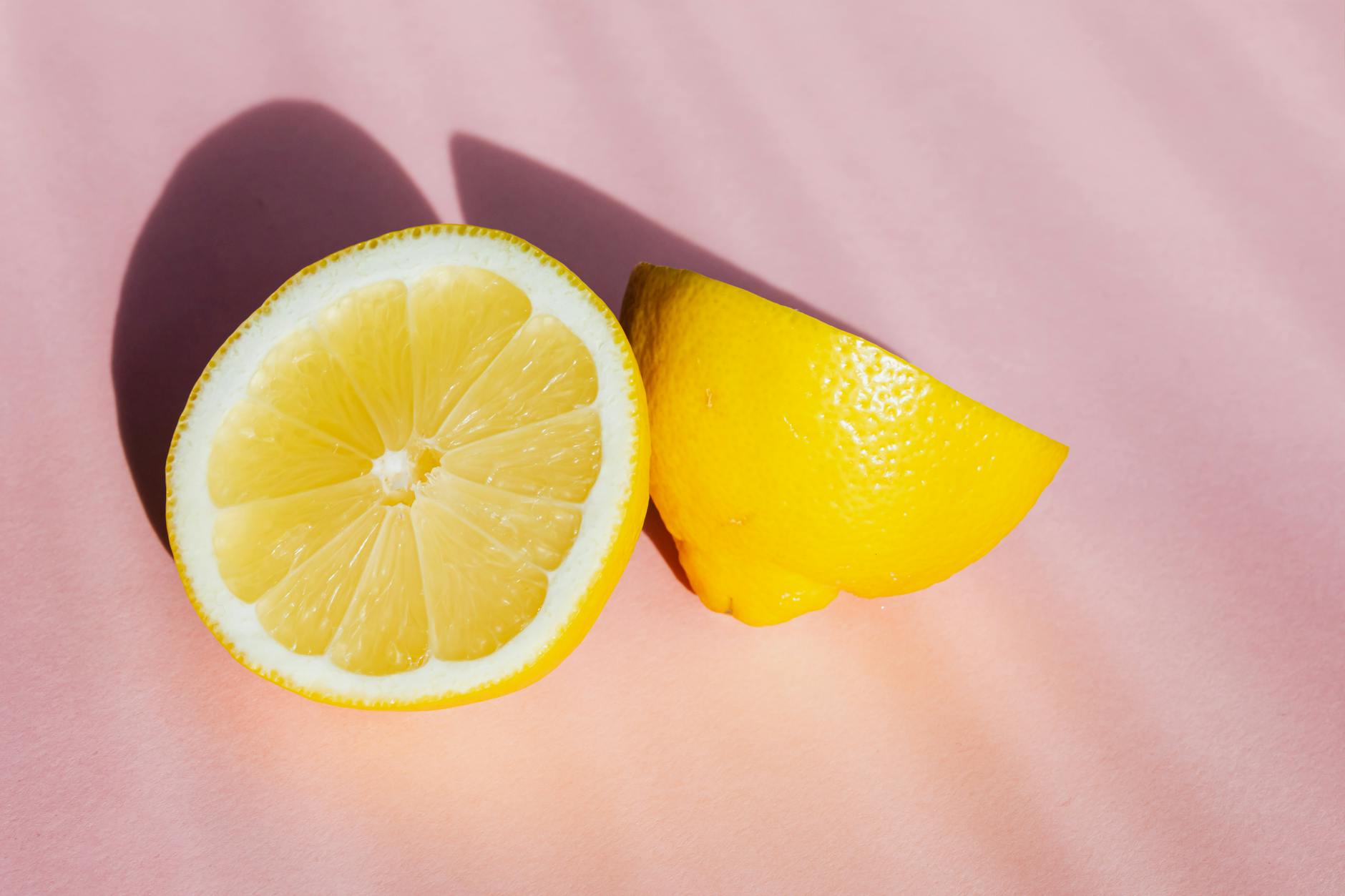 Fresh lemon halves on a pink background, symbolizing renewal and fresh starts