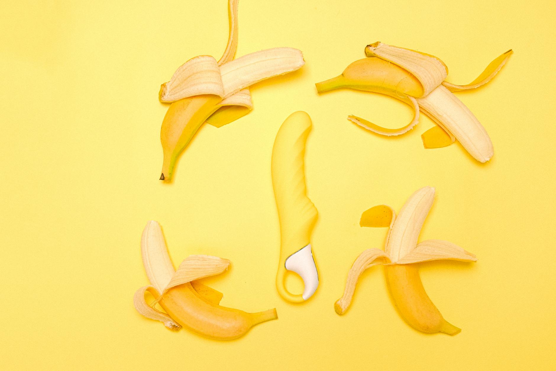 Bright yellow lemon vibrator surrounded by fresh lemons on a yellow background, symbolizing natural sensation and renewal