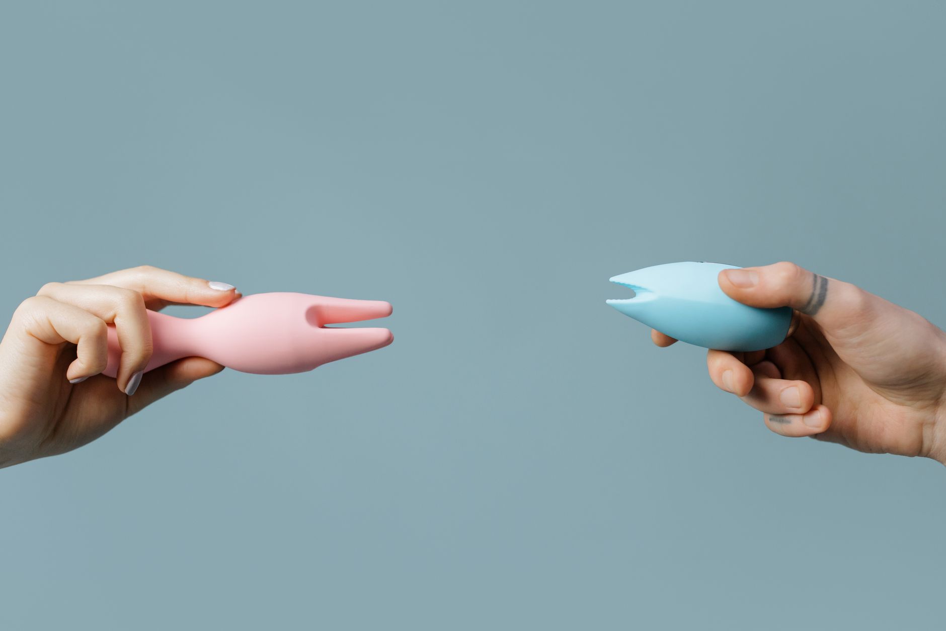 A blue silicone vibrator held in hand against a purple background, promoting self-love and pleasure during moments of calm.